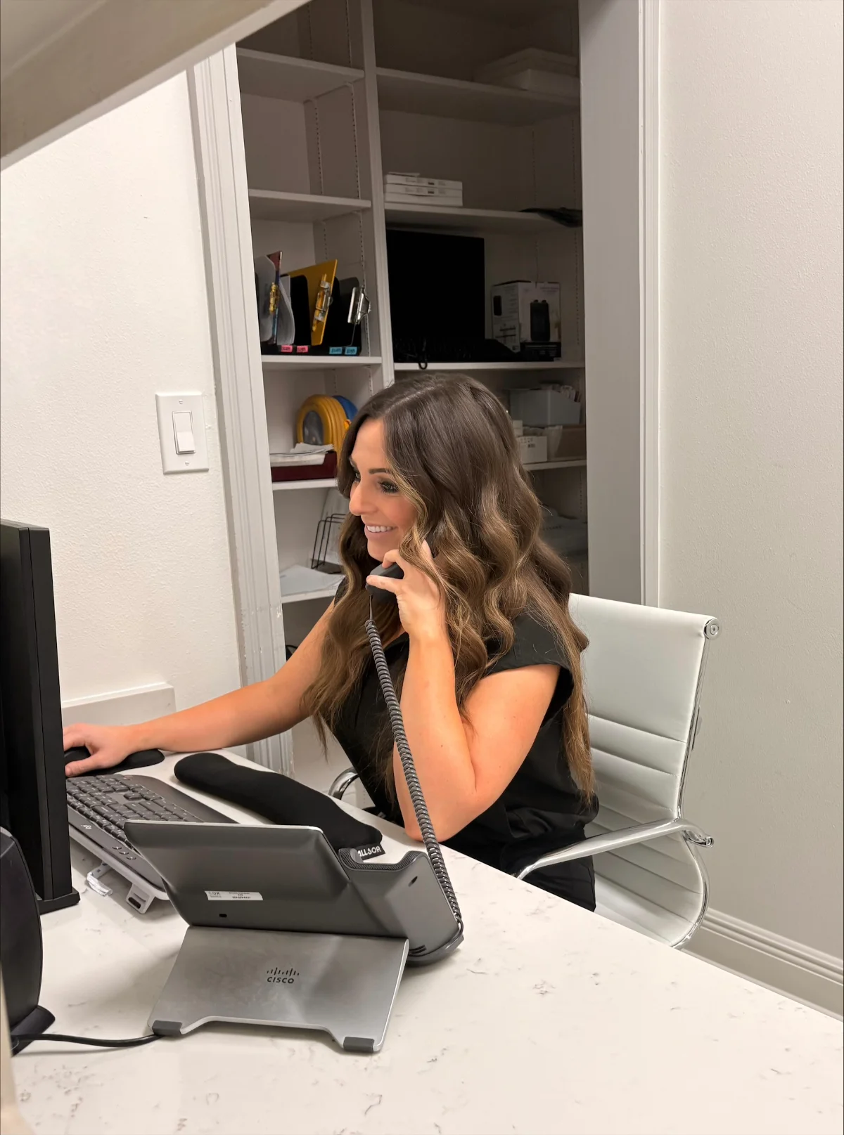 smiling front desk on phone